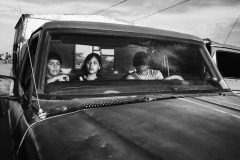 A family sits in a truck at Paraguachón, Colombia's border town, heading to the central city of Maicao on August 11, 2018. There, smuggling, theft, extortion, violence, and human trafficking are normalized practices. Those who can afford a bus ticket move to bigger cities of the Northern Colombian coast, such as Barranquilla, Cartagena, or to the capital city Bogotà. Others continue the journey on foot. Many end up living in the streets or informal camps on the outskirt of the town, with no guarantee of food, clean water, and health care.
Early in 2020, the Colombian government announced two new Special Stay Permits that would allow more than 100,000 Venezuelans to stay and work in the country, and ruled that children born in the country to Venezuelan parents could acquire Colombian nationality, but vast numbers of people remain dispossessed. A family sits in a truck at Paraguachón, Colombia's border town, heading to the central city of Maicao on August 11, 2018. There, smuggling, theft, extortion, violence, and human trafficking are normalized practices. Those who can afford a bus ticket move to bigger cities of the Northern Colombian coast, such as Barranquilla, Cartagena, or to the capital city Bogotà. Others continue the journey on foot. Many end up living in the streets or informal camps on the outskirt of the town, with no guarantee of food, clean water, and health care.
Early in 2020, the Colombian government announced two new Special Stay Permits that would allow more than 100,000 Venezuelans to stay and work in the country, and ruled that children born in the country to Venezuelan parents could acquire Colombian nationality, but vast numbers of people remain dispossessed.
