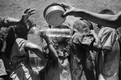 Venezuelan children hold plastic bottles filled with water while they wait in line for a free meal at a charity organization in Paraguachón, Colombia, on August 10, 2019. According to UNICEF, out of the 1.8 million Venezuelans settled in Colombia, 430 thousand are children and adolescents. Migrant children are trapped in a dangerous environment and, without access to education, they are born and grow with no horizon of comparison for their condition. As the unstable environment doesn't change, the children and the adolescents seem to have learned to live with a constant feeling of danger and exacerbated alertness. Families from neighboring Venezuela walk into Colombia to eat, fill bottles with potable water, and return home. Often, they are indigenous Wayuu, of Venezuelan nationality. Venezuelan children hold plastic bottles filled with water while they wait in line for a free meal at a charity organization in Paraguachón, Colombia, on August 10, 2019. According to UNICEF, out of the 1.8 million Venezuelans settled in Colombia, 430 thousand are children and adolescents. Migrant children are trapped in a dangerous environment and, without access to education, they are born and grow with no horizon of comparison for their condition. As the unstable environment doesn't change, the children and the adolescents seem to have learned to live with a constant feeling of danger and exacerbated alertness. Families from neighboring Venezuela walk into Colombia to eat, fill bottles with potable water, and return home. Often, they are indigenous Wayuu, of Venezuelan nationality.
