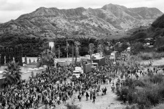 A ten thousand people caravan moves by walk and on trucks towards a barricade made by Guatemalan police officers to prevent them from continuing their northward journey in Vado Hondo, Guatemala, on January 18, 2021.
By chance, months after, the photographer met for a second time, in Mexico, a family he had photographed when the caravan had begun. A family of six, they crossed into the United States three times and were expelled back to Mexico. There, a cartel controlling the migrant trade kidnapped them for two weeks, eventually releasing the family so that they could take care of another woman that the same kidnappers had almost beaten to death. 
They eventually could have the older children, 5 and 7 years old, crossing the border alone, a telephone number marked with a pen on their arms so that American authorities could have their uncle living in Texas taking care of them. They crossed with their other two babies and finally reunited with their children in Texas, where they started the asylum-seeking process. When asked by authorities to prove they had walked with the fours children from Honduras, the photos depicting them together in Honduras and then in Mexico served as proof.