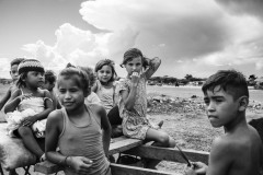 Venezuelan children sit in a cart in an informal settlement known as La Pista, located around an abandoned airport on the Maicao's outskirts in La Guajira, Colombia, on September 28, 2020.
In migrant settlements, people do not have running water or sanitation access. Health care has become a particular concern during the pandemic, as access to hospitals was limited to emergencies. People rely on medical brigades of international organizations that have no means for specific interventions other than treating generic ailments.
In 2020, the photographer worked in the area with the collaboration of leaders of the migrant community who assisted with the work and ensuring the families' consent to photograph. By the end of that year, the photographer ideated a project to promote self-representation and journalism for the community's children, women, and men. The United Nations Refugee Agency (UNHCR) offered funding to buy photo cameras and implement the project in a temporary center where people are provided food and housing for a month upon their arrival. Venezuelan children sit in a cart in an informal settlement known as La Pista, located around an abandoned airport on the Maicao's outskirts in La Guajira, Colombia, on September 28, 2020.
In migrant settlements, people do not have running water or sanitation access. Health care has become a particular concern during the pandemic, as access to hospitals was limited to emergencies. People rely on medical brigades of international organizations that have no means for specific interventions other than treating generic ailments.
In 2020, the photographer worked in the area with the collaboration of leaders of the migrant community who assisted with the work and ensuring the families' consent to photograph. By the end of that year, the photographer ideated a project to promote self-representation and journalism for the community's children, women, and men. The United Nations Refugee Agency (UNHCR) offered funding to buy photo cameras and implement the project in a temporary center where people are provided food and housing for a month upon their arrival.