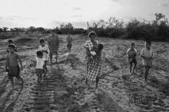 Family members walk through the tracks of bulldozers that destroyed their homes; in the land they were living on and that was bought out from under them.