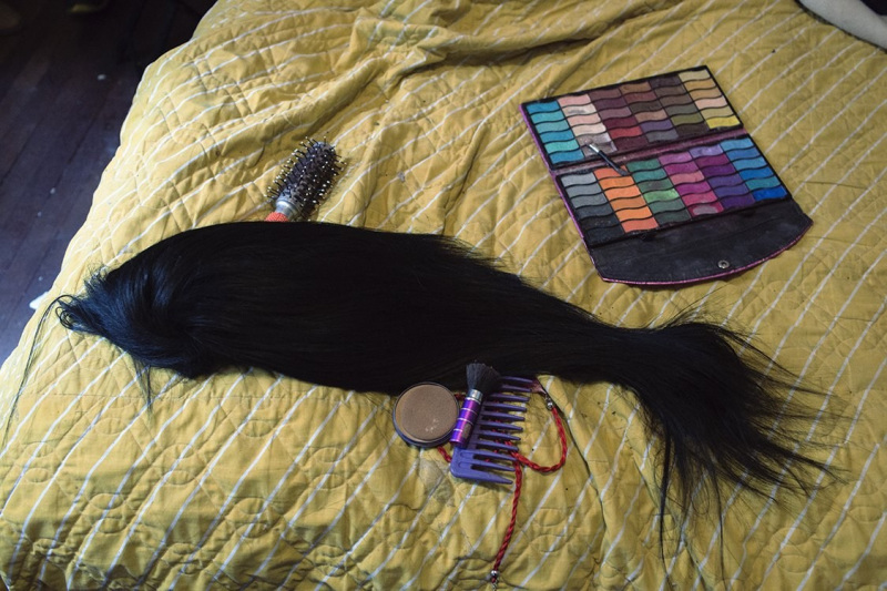 Wig and make up tools on the Luisa's bed.